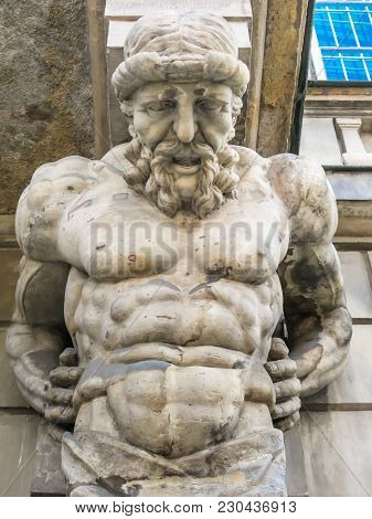 Atlas Statue Holding A Portico. Stone Sculptures Of Male Torsos