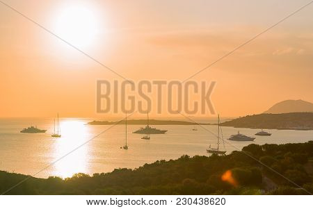 Sunrise With Yachts And Ships At Porto Rotondo In Costa Smeralda At Mediterranean Sea, Sardinia, Ita