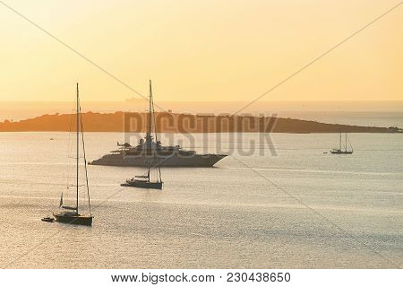 Sunrise With Yacht And Ships At Porto Rotondo On Costa Smeralda At Mediterranean Sea, Sardinia, Ital