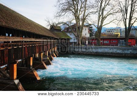 Thun, Switzerland - January 1, 2014: Old Wooden Sluice Bridge And The Old City Of Thun. Thun Is A Ci