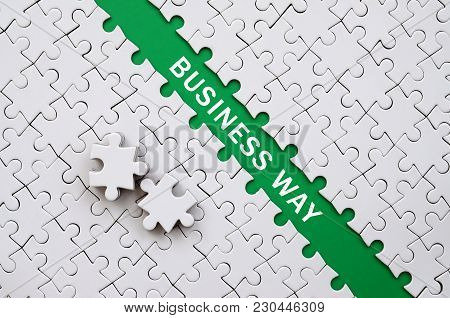 Business Way. The Green Path Is Laid On The Platform Of A White Folded Jigsaw Puzzle. The Missing El