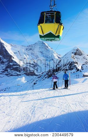 Cable Car Cabin And Skiers On Winter Sport Resort In Swiss Alps In Mannlichen, Switzerland