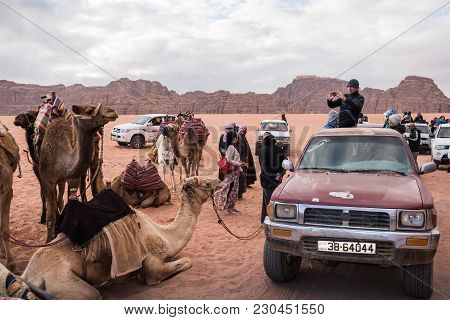 Wadi Rum, Jordan - December, 25, 2017: Tourists And Bedouins Near Camals In Wadi Rum Desert In Jorda