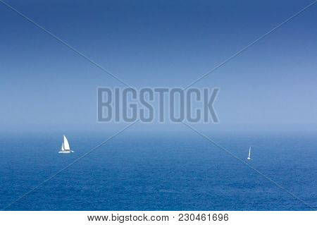 A Sailboat And A Catamaran Sailing At The Mouth Of The Tagus River On The Coast Of Cascais. Portugal