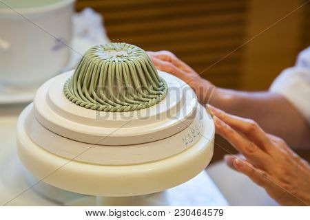 A Porcelain Maker Demonstrates How To Make Her Porcelain Goods At Her Work Station.