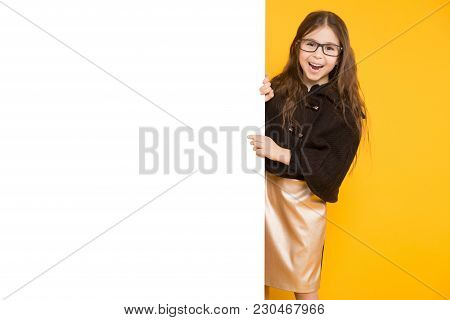 Portrait Of Cute Long-haired Happy Little Girl In Jacket And Eyeglassesisolated On Yellow Background