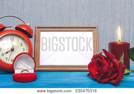 Wedding Ring In A Gift Present Box And Empty Photo Frame Of A Loved One Copy Space And Red Rose Flow