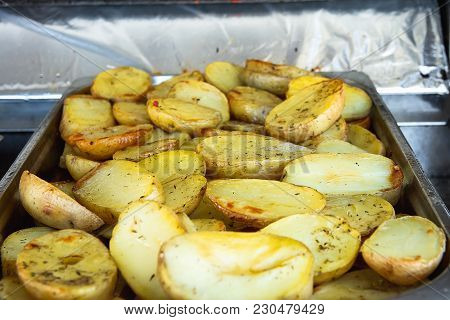 Hot Baked Seasoned Halved Potatoes On Trey Cooked In Oil. Street Food. Appetizing Golden Crust. City