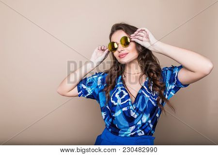 Smiling Summer Woman With Sunglasses Over Bright Background. Studio Shot, Copy Space