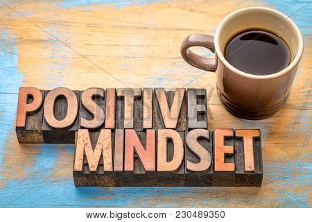 positive mindset - word abstract in vintage letterpress printing blocks with a cup of coffee