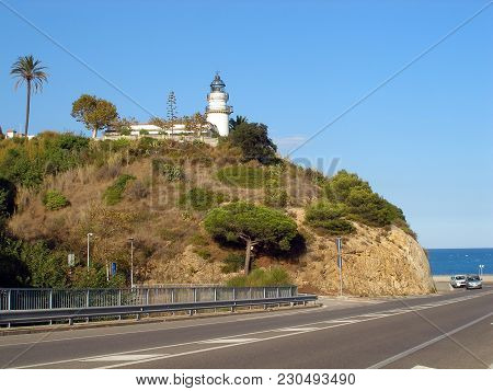 Lighthouse On A Mountain And Road Beside Sea