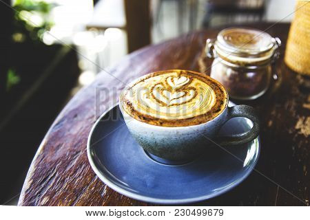 Cup Of Hot Cappucino Is On Wooden Table Background. Hippster Style