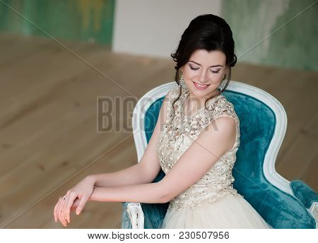 Half Length Portrait Of Brunette Smiling Woman Dressed In Sleeveless Light Evening Dress.