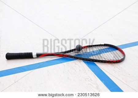 Squash Racket And Ball On The Wooden Floor. Racquetball Equipment On The Court. Photo With Selective