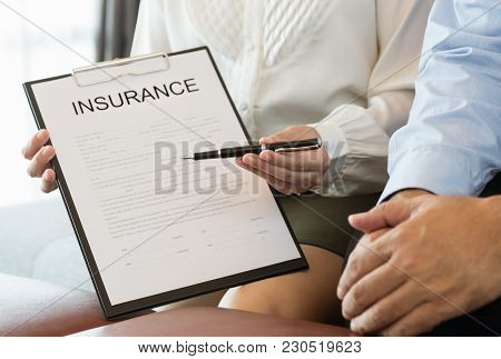 Insurance Agent Holding Pen, The Policyholder And Explain Insurance Policy To Customer. Life Insuran