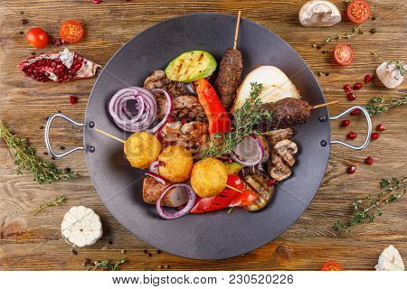 A Black Dish With Barbecue Meat. Still-life On A Wooden Background.