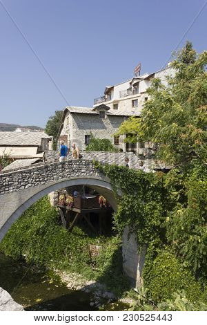Mostar, Bosnia And Herzegovina - August 17 2017: Two People On The Historic Kriva Cuprija Old Bridge