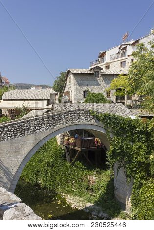 Mostar, Bosnia And Herzegovina - August17 2017: Kriva Cuprija Ancient Bridge In Mostar, Surrounded B