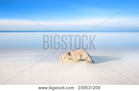 A Rock On A White Sand Beach And Blue Ocean On Horizon. White Beach Rosignano Vada. Tuscany, Italy. 