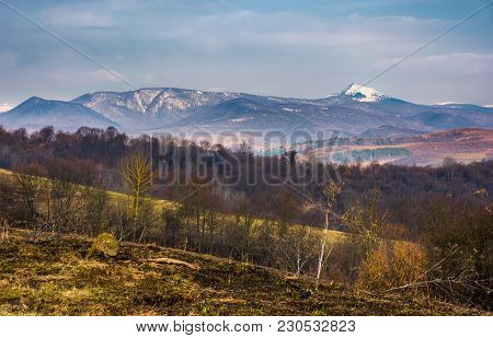 Springtime Landscape In Carpathian Mountains. Mountain Ridge With Pikui Snowy Peak In The Distance