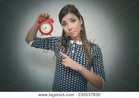 Strict Boss Woman Holding In Hands Red Alarm Clock And Showing Time By Her Index Finger. Job Or Scho