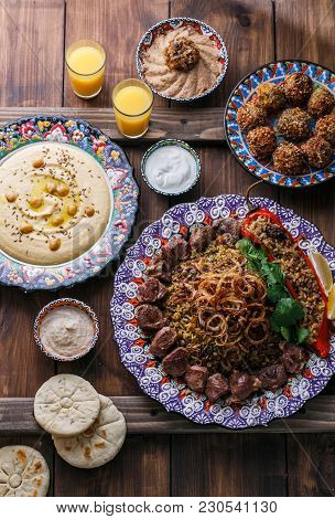 Middle Eastern Or Arabic Pilaf With Hummus, Falafel, Eggplant Dip And Pitas Top View, Wooden Backgro