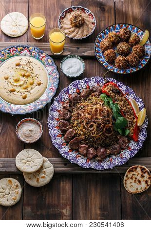 Middle Eastern Or Arabic Pilaf With Hummus, Falafel, Eggplant Dip And Pitas Top View, Wooden Backgro
