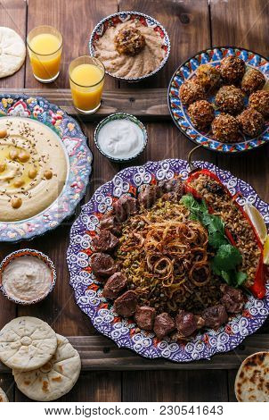 Middle Eastern Or Arabic Pilaf With Hummus, Falafel, Eggplant Dip And Pitas Top View, Wooden Backgro