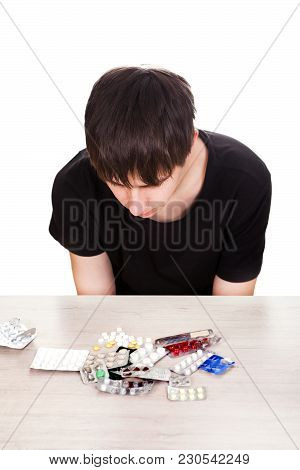 Young Man With A Pills On The Table