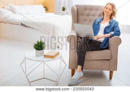 Feeling Good. Calm Peaceful Young Woman Sitting In A Comfortable Armchair With Her Eyes Closed And F