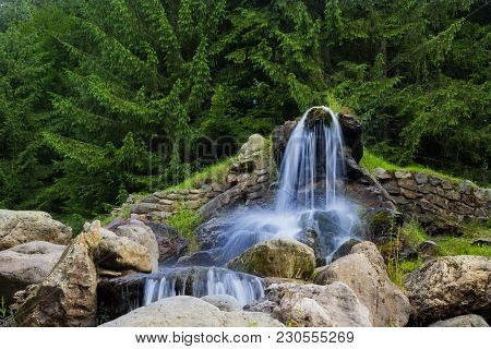 Beautiful Artificial Waterfalls, In The Background Are Green Pine Trees. (izvorul Minunilor) Romania
