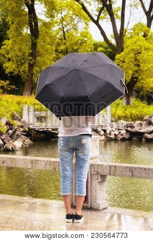 A Woman Holding An Umbrella Within Li Yuan, A Traditional Chinese Garden, In Zhaojialou Town In Shan