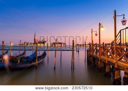 Venice With Famous Gondolas  In Lagoon At Sunrise As A Background  Can See The Chucrh Of San Giorgio