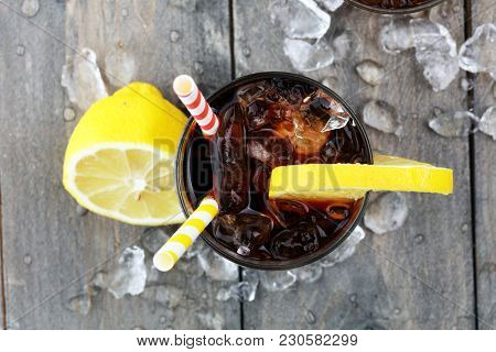 Softdrink With Ice Cubes, Lemon And Straw In Glass.