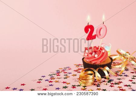 20th Birthday Cupcake With Candles, Sprinkles And Ribbon On Pink Background. Card Mockup, Copy Space