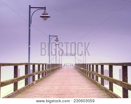 Old Wood Beach Bridge In Goehren With Nobody. Autumnal Misty Weather With Cloudy Sky.