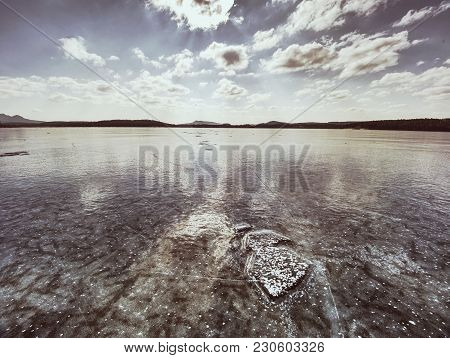 Shining Piece Of Clear Ice On Frozen Lake. Cracks Inside Many Reflections Of Sun Rays. Beauty Of Win