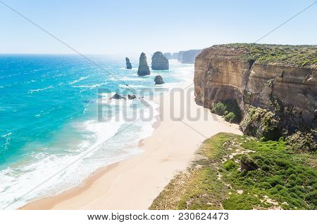 Twelve Apostels With Beach And Grass And Backlight At The Great Ocean Road, Victoria, Australia