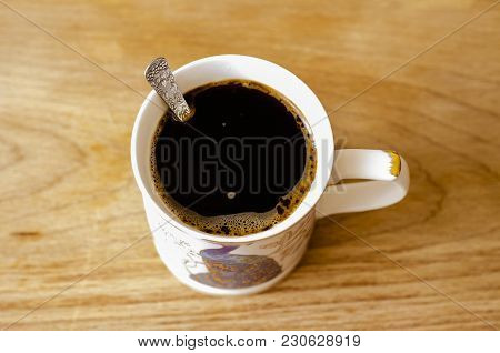 Coffee In A White Cup With A Beautiful Pattern On A Natural Wooden Board