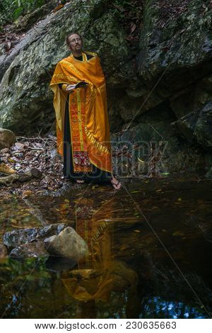 KOH CHANG, THAILAND - MAR 9, 2018: Orthodox priest during sacrament of spiritual birth - Baptism. There are currently 10 Orthodox parishes in Thailand, Orthodoxy is practiced by 0.002% of population.
