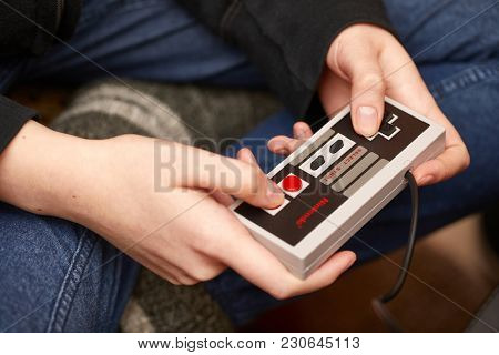 BUDAPEST, HUNGARY - FEBRUARY 17, 2018: Playing the classic Nintendo NES console from the 80s, controller closeup