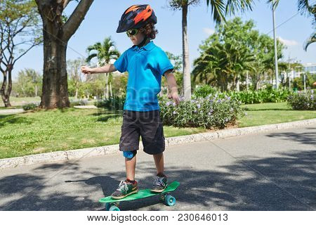 Little Boy Learning How To Ride On Skateboard