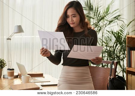 Smiling Eautiful Business Woman Comparing Information In Two Documents