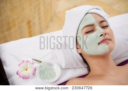 Beautiful Asian Young Woman Lying With Clay Mask On Half On Her Face