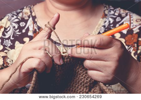 Close Up Hand Of Old Woman Knitting Woolhate On Wooden Table Background
