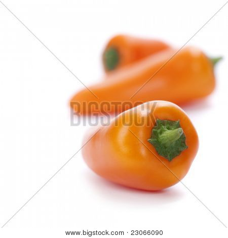  peperoni freschi arancione sopra bianco