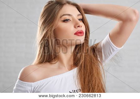 Attractive Model Wearing Eye Make Up And Red Lipstick Posing In White Top Lifting Head Up And Lookin