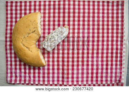 Piece Of Hot Salamy Put Near A Savoury Doughnut On A Red Napkin