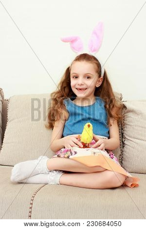 Portrait Of Little Girl In Easter Pink Bunny Ears Holding Toy Chick. Little Girk In Easter Bunny Ear