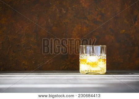 Glass Of Whiskey On Dark Background. Close Up. Sunny Day
